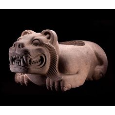 a stone statue of a dog with its mouth open and eyes wide open, on a black background