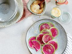 a plate with slices of watermelon sitting on top of it next to other dishes