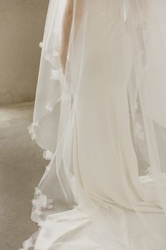 a woman in a wedding dress with a veil over her head