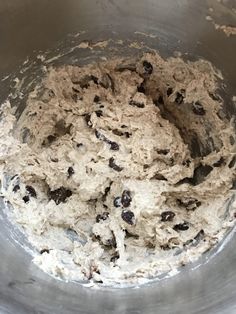 a metal bowl filled with batter and raisins