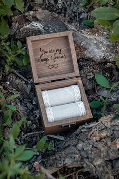 an open wooden box with two rolls of toilet paper in it sitting on the ground