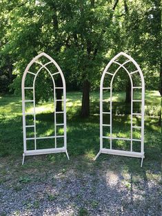 two white metal archs sitting in the grass