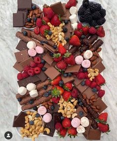 a platter filled with assorted chocolates, strawberries, and other treats