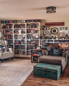 a living room filled with furniture and bookshelves covered in lots of bookcases