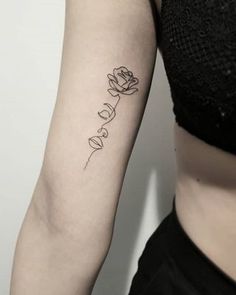 a woman's arm with the word love tattooed on it and a rose in cursive writing