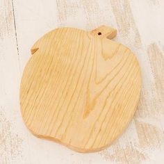 a wooden cutting board sitting on top of a white table