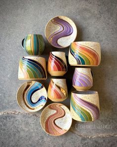 several bowls are stacked on top of each other with different colors and shapes in them