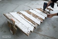 a person sanding down some wood with a power drill and nailgung on it