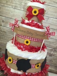 a three tiered diaper cake decorated with sunflowers and burlocks