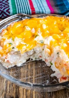 a casserole dish with chicken and cheese in it sitting on a wooden table