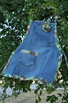 a denim skirt hanging on a tree branch