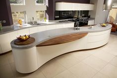 a modern kitchen with an island counter top and white cabinets, is pictured in this image