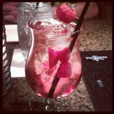 a glass filled with liquid and strawberries