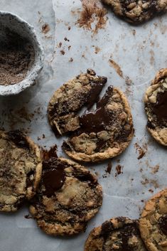 chocolate chip cookies on parchment paper next to a cup of cocoa