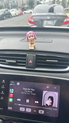 a car dashboard with an electronic device on it's center console and a toy monkey sitting on top of the dash board