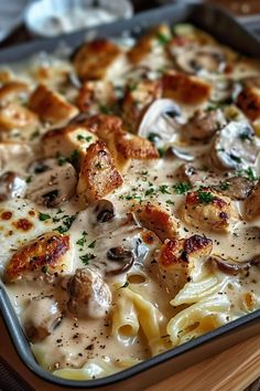 a casserole dish with chicken, mushrooms and pasta in a creamy white sauce