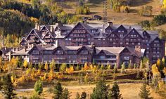 an aerial view of a large building surrounded by trees in the fall season with yellow and orange leaves