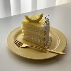 a piece of cake on a yellow plate with a fork and lemon wedge next to it