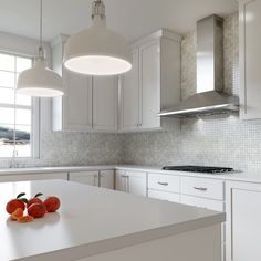 two oranges are sitting on the counter in this white kitchen with stainless steel appliances