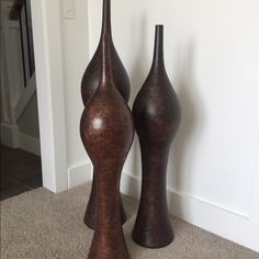 two brown vases sitting next to each other on the floor