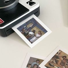 a polaroid camera sitting on top of a table next to some pictures and photos