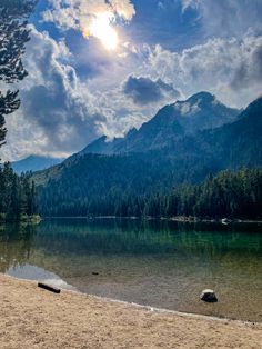 the sun shines brightly over a mountain lake