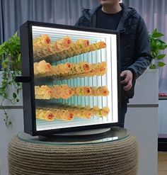 a man standing in front of a tv with flowers on it