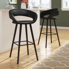 two black bar stools sitting next to each other in a room with green walls