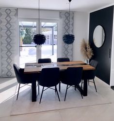 a dining room with black chairs and a wooden table