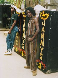 two men standing next to each other in front of a sign that says king jammy