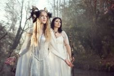 two women dressed in white standing next to each other with long hair and horns on their heads