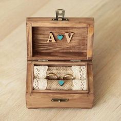 two wedding rings in a wooden box with the word va engraved on it's lid