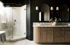 a bathroom with black walls and white tile on the floor, along with two sinks