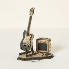 a miniature guitar and amp stand on a white surface