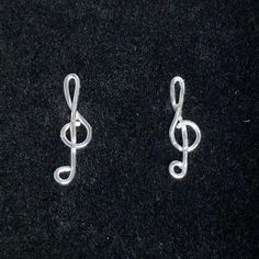 two silver earrings with musical notes on them