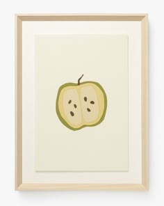 an apple with two slices cut in half on a white wall above a framed photograph