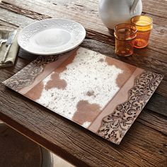 a wooden table topped with plates and cups