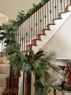 christmas garland and greenery on the bannister at the bottom of stairs in a home