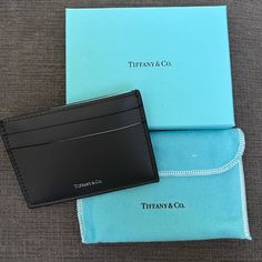 Nwot Authentic Tiffany & Co. Card Holder Material: Leather Color: Dark Gray/Black Size: 4”L X 2.75”H Two Exterior Card Pockets On Front And Back. One Interior Pocket. This Item Has Never Been Used And Comes With Dust Bag, Gift Box, And Ribbon. Feel Free To Ask Questions! Co Card, Tiffany Eyeglasses, Tiffany Key, Tiffany Necklace, Vintage Tiffany, Charm Holder, Round Tags, Cat Keychain, Tiffany Style