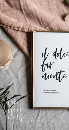 an open book on top of a table next to a cup and saucer with flowers