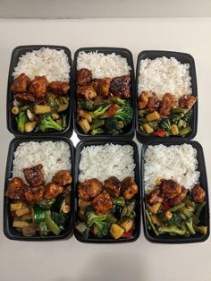 six black plastic containers filled with rice and veggies on top of each other