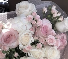 a bouquet of white and pink roses in a car