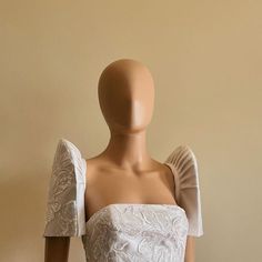 a mannequin wearing a white dress with ruffles on it's shoulders