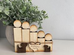 a group of wooden pegs with a heart in the middle on a table next to a potted plant