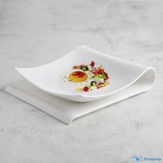 two white plates with food on them sitting on a gray tablecloth covered flooring