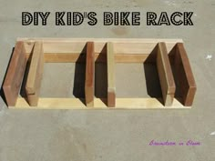 the diy kid's bike rack is made out of wood and has four blocks attached to it