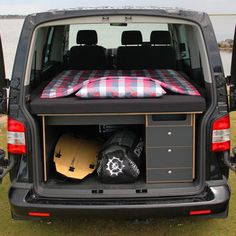 the back end of a van with its cargo compartment open and surfboards in it