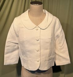 This is a sweet, vintage, cotton jacket or suit jacket from the 1970s or so. Label reads, Sears Fashion, Sears, Roebuck and Co. U.S.A. No size tags. The bust measures 38" with measurements below.  Made of white cotton or cotton blend with a horizontal ribbed texture. It has a button front with 4 fabric covered buttons, 3/4 length sleeves & a large round collar.  There are 2 faux pockets on the front. Slightly boxy shape with the hemline to the waist area. Fully lined. Charming!   The jacket is i Retro Spring Blazer With Lapel Collar, Vintage Coats, Fashion White, Fabric Covered Button, Womens Blazers, Vintage Coat, Ribbed Texture, Cotton Jacket, Vintage Cotton