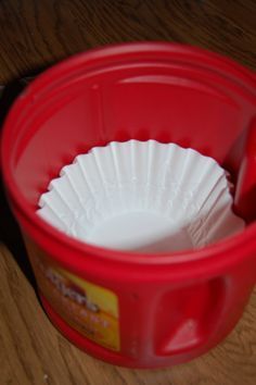 a red plastic cup sitting on top of a wooden table