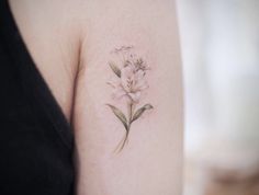 a woman's arm with a flower tattoo on the left side of her arm